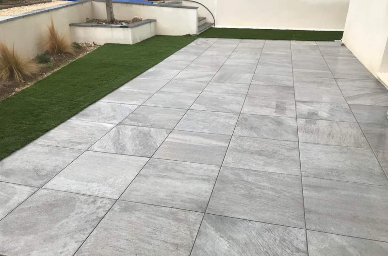 Terrasse en dallage à Sausset les pins avec du gazon synthétique pour amener un peu de verdure